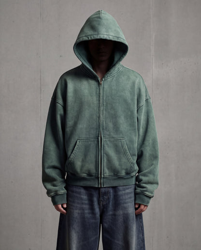 Green hoodie worn by a person against a gray background